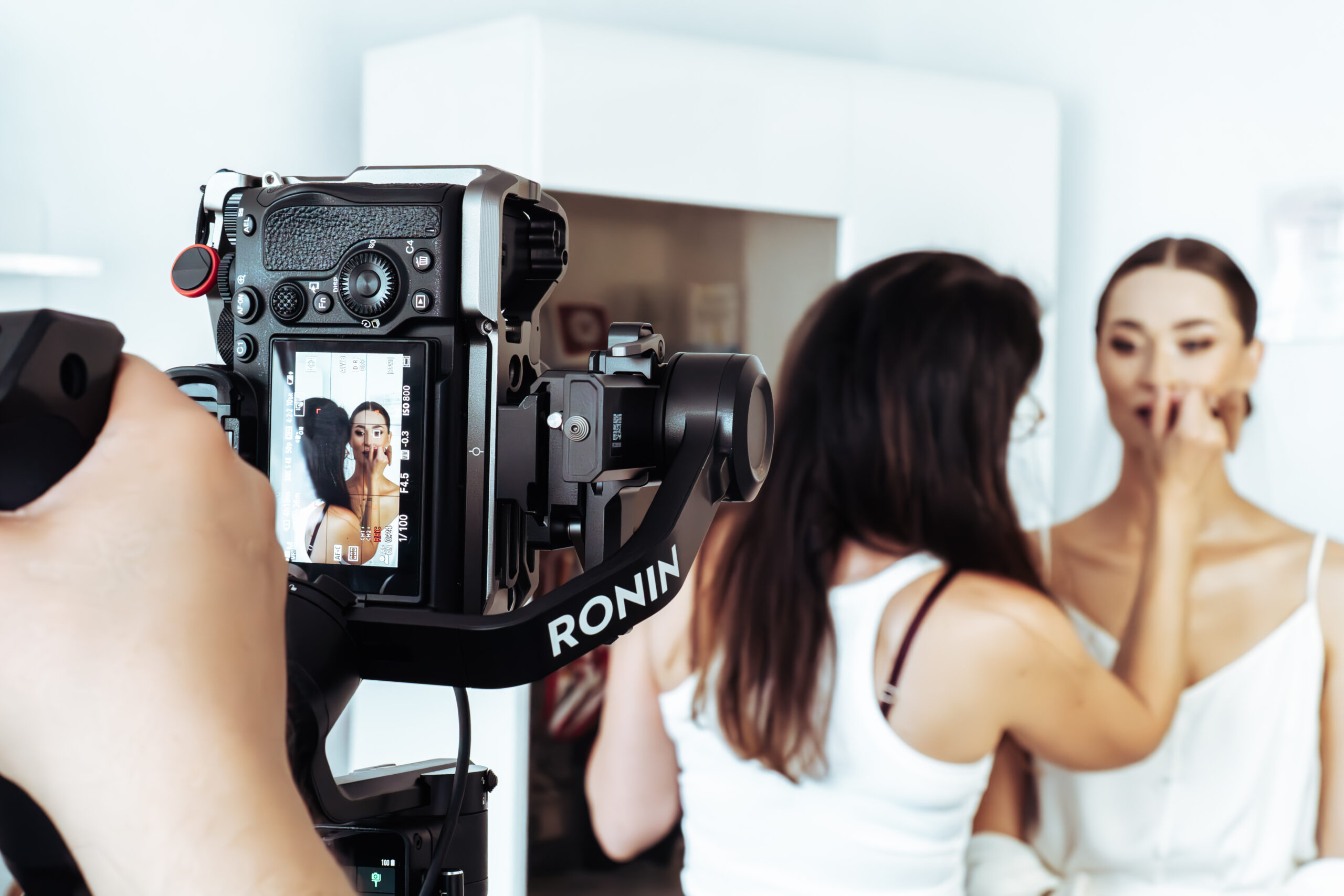 Aparat na gimbalu na pierwszym planie podczas kamerowania makijażu panny młodej. Film ślubny i nowoczesny reportaż Gorzów Wielkopolski, Międzyrzecz.