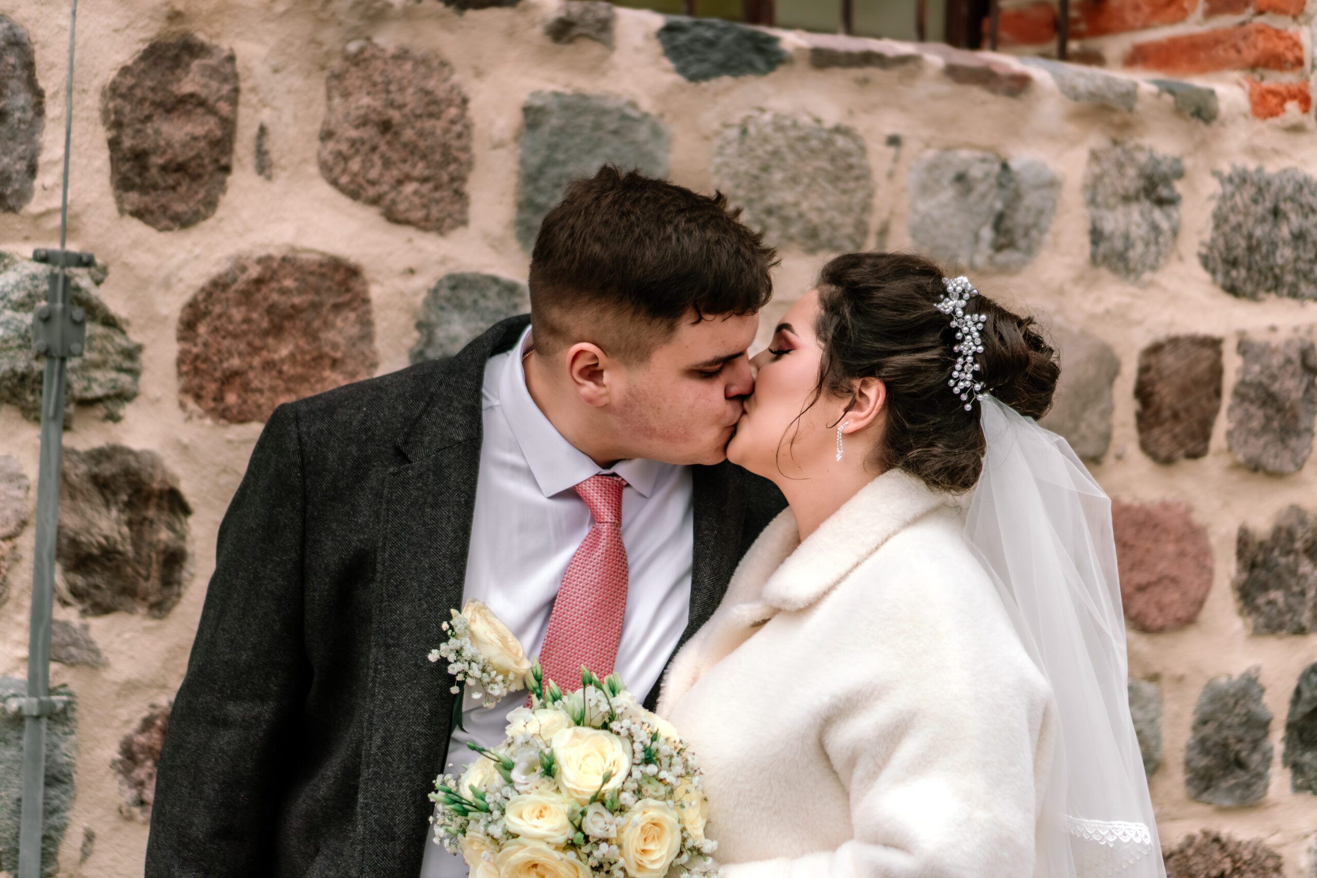 Pocałunek pary młodej na tle murów cerkwi w Brzozie fotografia ślubna Gorzów