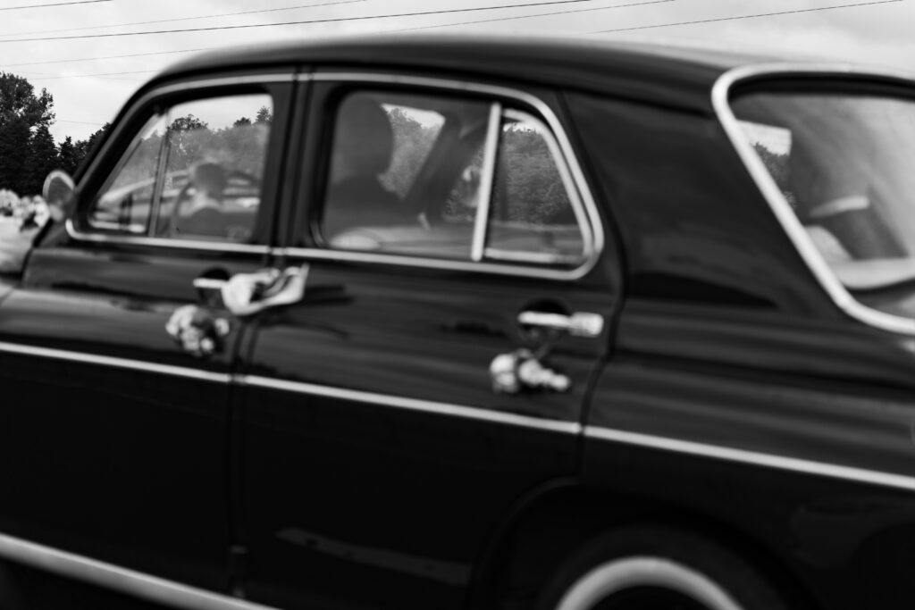 Czarno-białe zdjęcie Warszawy 203 w ruchu, zabytkowe auto do ślubu. Fotografia ślubna Gorzów Wielkopolski, Lubniewice.