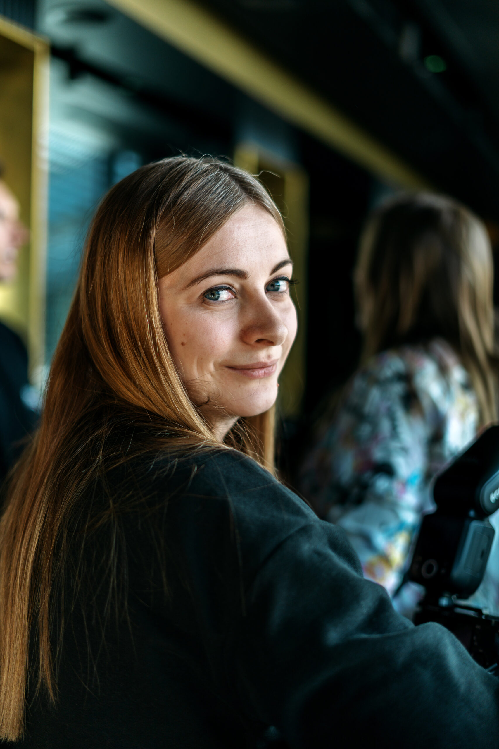 Portret uśmiechniętej Justyny podczas pracy na planie zdjęciowym, naturalne ujęcie zza kulis reportażu ślubnego – fotograf ślubny Gorzów Wielkopolski.