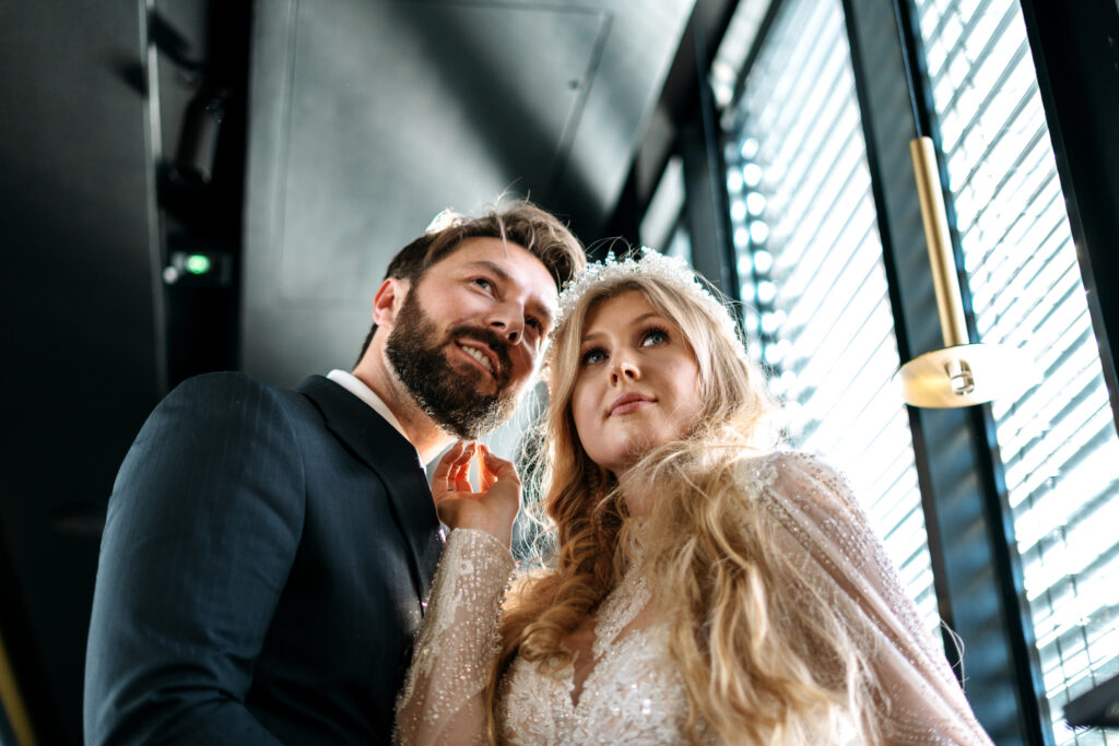 Zbliżenie na twarze pary młodej wpatrzonej w górę w nowoczesnym wnętrzu w naturalnym świetle - nowoczesny reportaż ślubny Szczecin | Durka Studio.