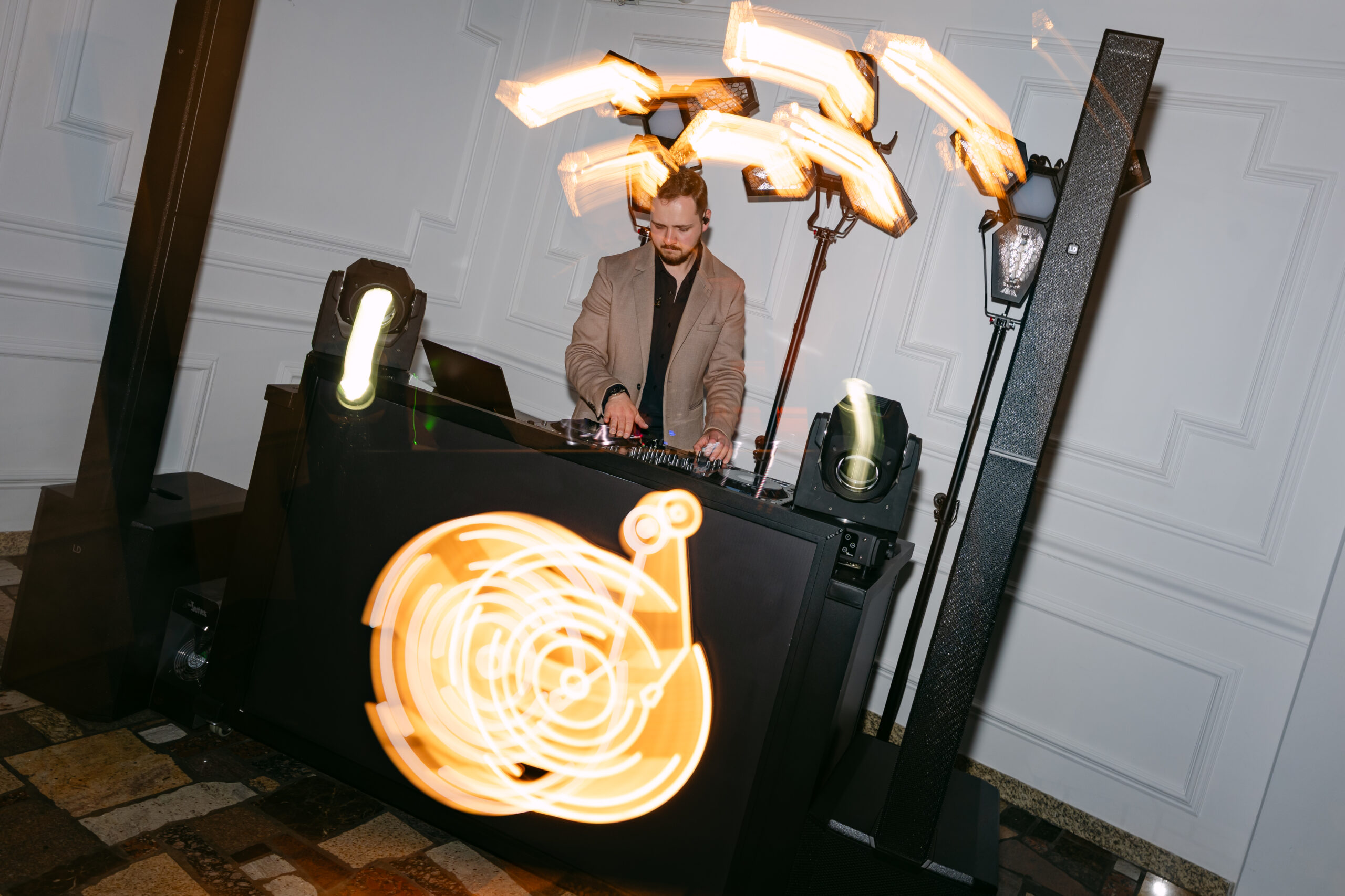 DJ grający na konsoli podczas wesela Moniki i Sebastiana w Dworku Kurowskim. Dynamiczne ujęcie ze świetlnymi refleksami, nowoczesny reportaż ślubny.